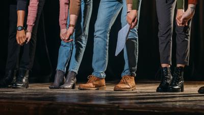 panoramic shot of actors and actresses bowing on stage