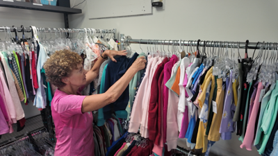 A Clothing Our Kids volunteer sorts through new clothes.