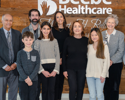 a group of recipients pose in front of a beebe healthcare sign for a photo 