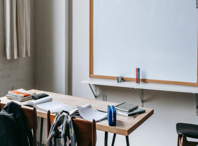 Desk and whiteboard in school classroom