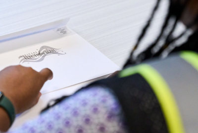 woman looking at white envelope