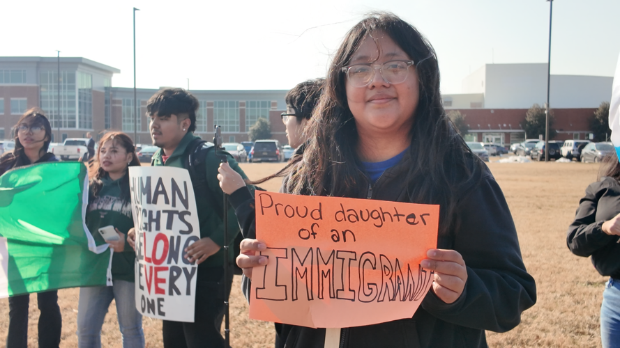 Sussex Central High School student holding a sign that reads "Proud daughter of an immigrant."