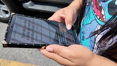 Marisol Velásquez reads state website information in Spanish using a translation app.