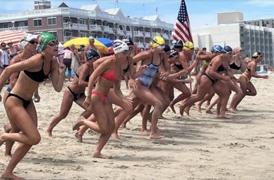 Lifeguards running on a beach with an American flag.