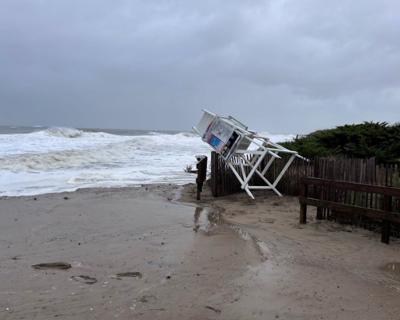 A lifeguard stand pushed up against dune fencing in Ocean City.  The rough surf of the ocean is to the left. Lifeguards their ended season as Nor’easter brings dangerous surf.