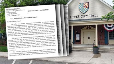 A picture of four pages of the report in front of city hall.