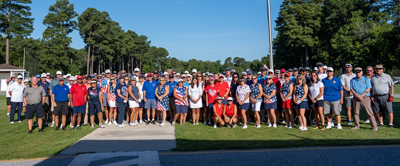 a large group of golfers pose for a photo 