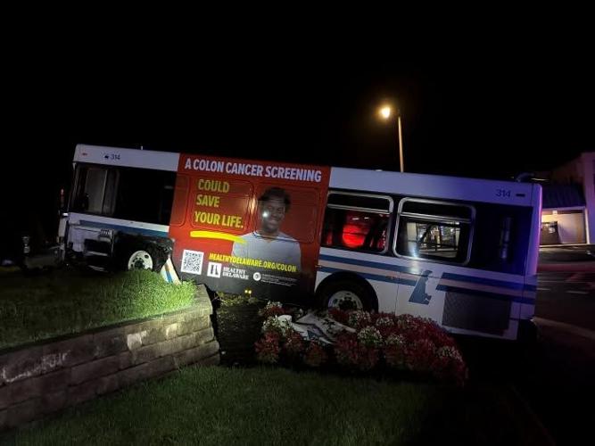 A flashlight shines on a DART bus that crashed into a short wall.