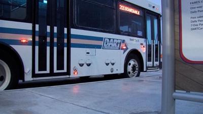 An image of a DART bus waiting at a bus stop.