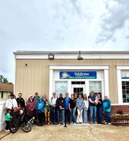 A group of people stand together outside of the Milton Chamber of Commerce.