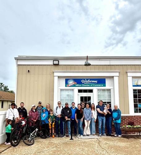 A group of people stand together outside of the Milton Chamber of Commerce.