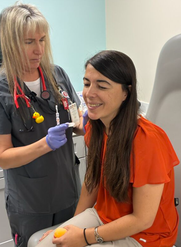 WOMAN GIVING WOMAN A SHOT