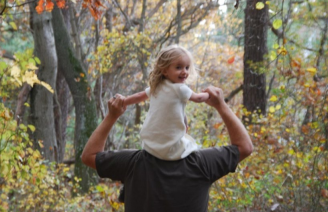 a young girl sits on a mans shoulders walking through the window 
