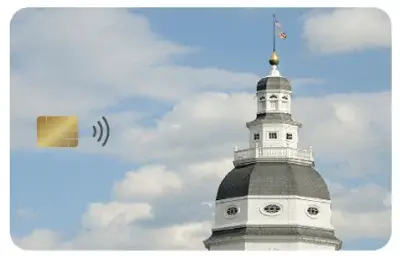 A photo of Maryland's chip-and-tap EBT card. A blue sky with clouds and the top of a building is shown on the card. 