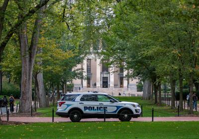 University Police car sits on Pollock Road in front of Pattee and Paterno Libraries