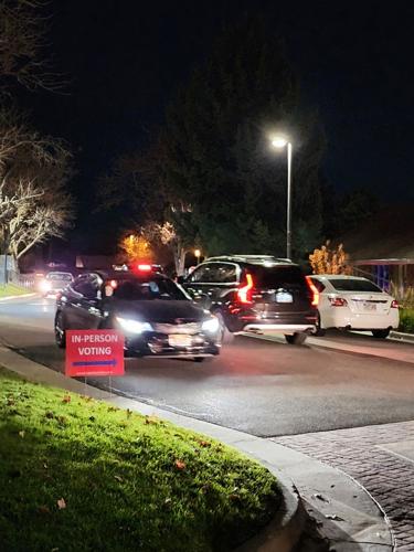 Voters wait to drop ballots at a polling station on election night