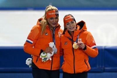 Dutch pair Jutta Leerdam (L), the silver medallist, and the new Olympic 500m speed skating champion Femke Kok