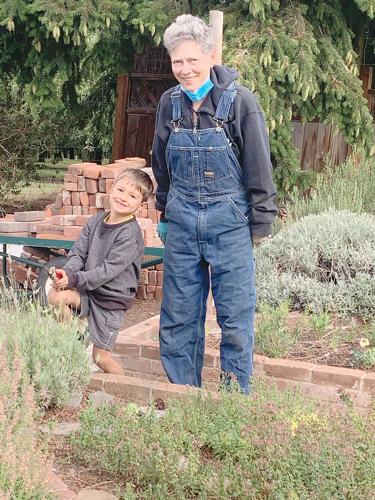 Margo Dameier photo Central Gorge Master Gardener volunteer Anne Gehrig welcomes the help of her grandson, Orrin Apland in the Herb Garden at the OSU Hood River County Extension Service campus. Extension Services are located in nearly every county in th...