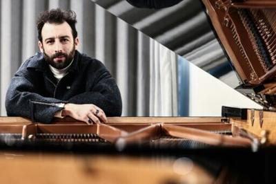 Julien Cohen can be seen leading the troupe of 30 performers on a grand piano