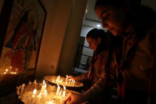 Hanaa Masoud lights candles for her husband Boutros Bashara, who was among those killed in the attack in June