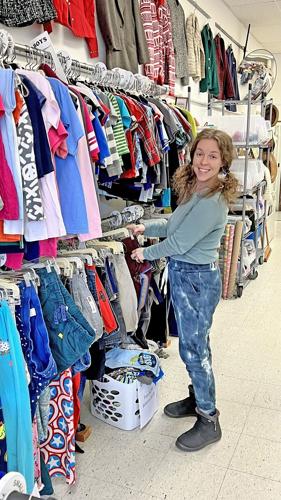 Store clerk Rachel Johnson adds new items to the clothing racks. Photo by Tamara Kaufman
