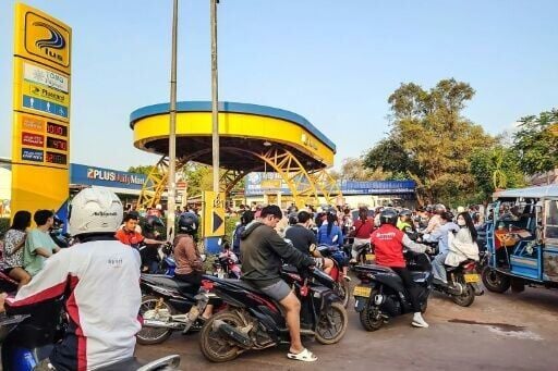 Motorists wait in a queue to refuel their vehicles at a petrol station in Vientiane on March 16, 2026