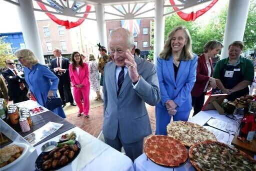 Britain's King Charles and Queen Camilla take in local food offerings at a block party in Front Royal, Virginia, as Governor Abigail Spanberger looks on