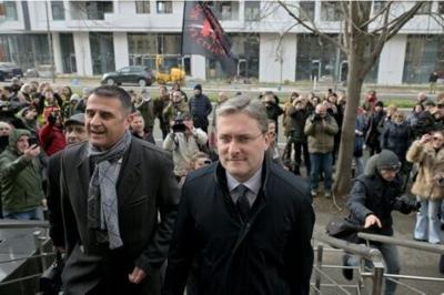 Culture Minister Nikola Selakovic, centre, arrives at the Belgrade courthouse greeted by dozens of protesters