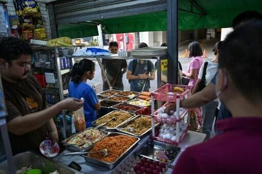 People buying food at a curbside canteen in Manila on April 7, 2026