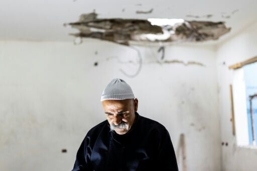 A man assesses the damage in a building in north Israel that was hit overnight by a rocket fired from Lebanon