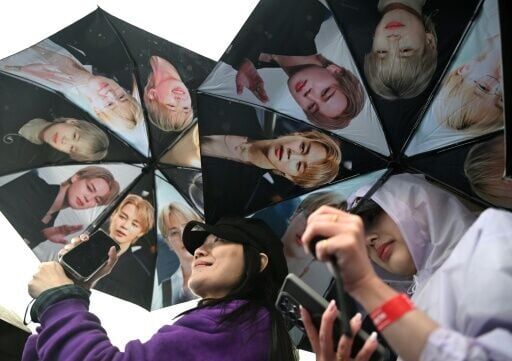 BTS fans hold umbrellas featuring members of K-pop boy band BTS as they arrive at the stadium in Goyang.