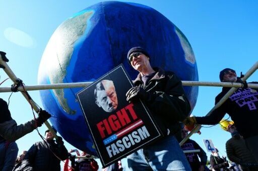 A protester in Washington holds a sign that compares US President Donald Trump to Nazi leader Adolf Hitler