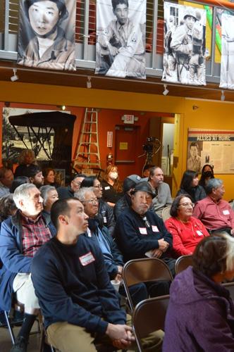 A crowd sits under the banners of Nisei servicemen, part of the current exhibit "A Long Road to Travel," at the Hood River Nisei WWII Veterans exhibit reception held at the History Museum of Hood River County Dec. 3. Trisha Walker photo