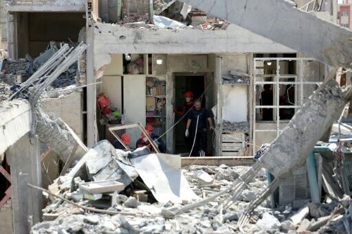 Firefighters at a bombed-out residential building in Tehran