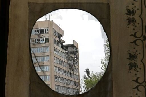 A building damaged by recent strikes is seen from the Golestan Palace in Tehran on April 4, 2026