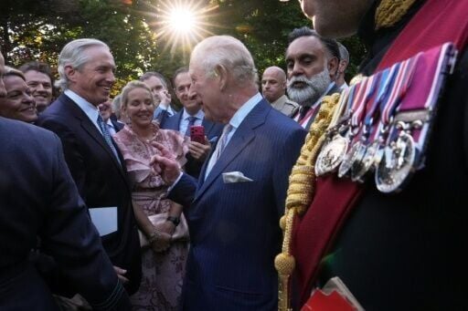 King Charles III chats with guests at a garden party at the British ambassador's residence in Washington