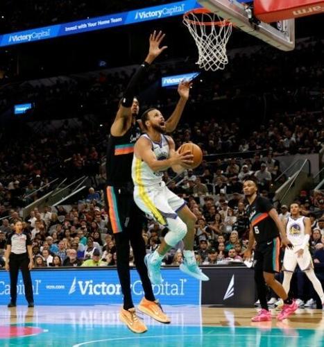 Stephen Curry of the Golden State Warriors scores against Victor Wembanyama in the Warriors' NBA victory over the San Antonio Spurs