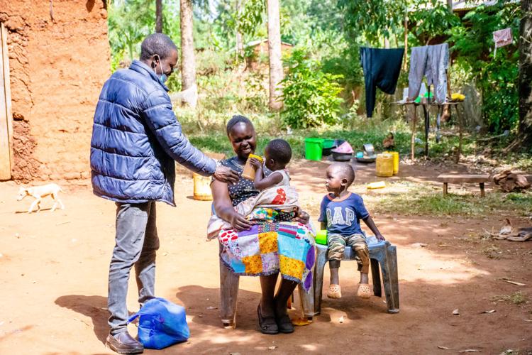 FAITH'S mother with her granddaughter receiving food aid from GRECA while Faith is in training.jpeg