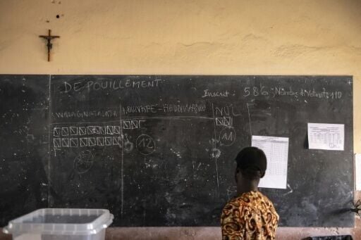 An electoral official views early results during counting at a polling station in Porto-Novo
