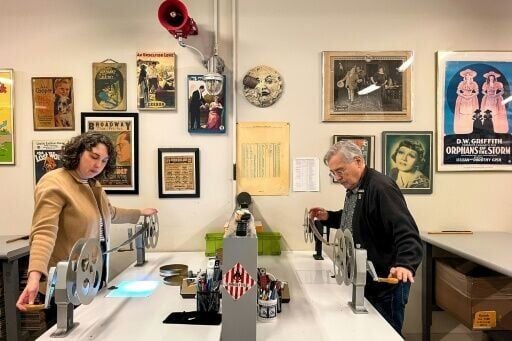 Nitrate Film Vault technician Courtney Holschuh (L) and vault leader George Willeman (R) unspool nitrate film on reels in a workspace at the nitrate film vault