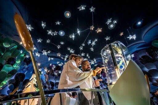 Visitors looking at watches on display at the booth of Van Cleef & Arpels