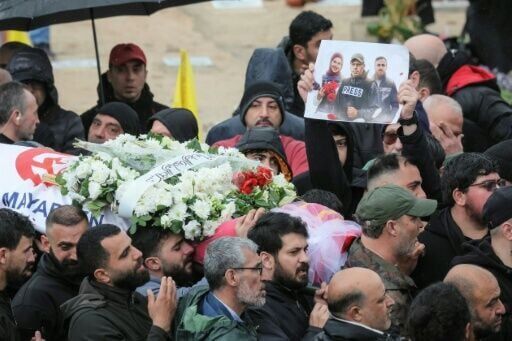 Mourners carry the body of one of the three journalists killed in southern Lebanon