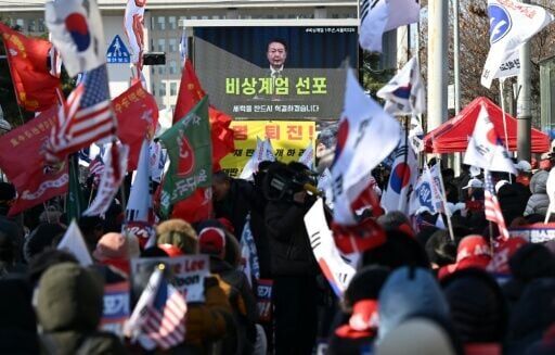 Supporters of South Korea's ousted president Yoon Suk Yeol watch a video of him declaring martial law during a rally marking the first anniversary of the botched takeover.