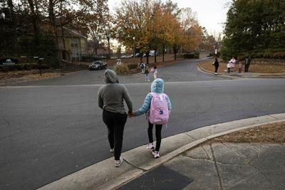 An undocumented Honduran immigrant walks her child to a school bus stop in November 2025 at an unspecified location in the U.S.