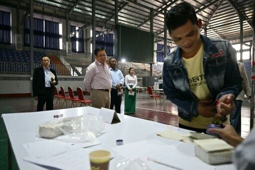 Myanmar military chief Min Aung Hlaing (front C) visits a polling station during the final phase of a junta-run vote critics say will prolong the army's grip on power