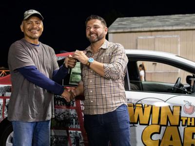 Columbia Gorge Toyota owner Aaron Carter hands raffle winner Juan Rojas