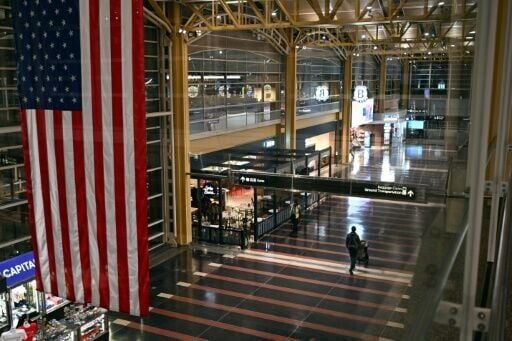 A passenger walks through the check-in area of Ronald Reagan National Airport in Washington, DC, on January 24, 2026, after thousands of flights across the United States were cancelled due to a winter storm