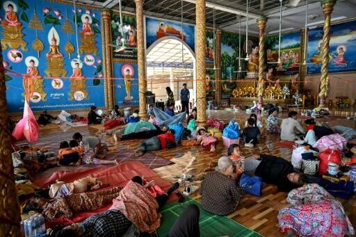 Residents rest inside a temple after they evacuated following clashes along the Cambodia-Thailand border, in Siem Reap province