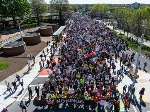People hold banners, signs and flags as they march near the Georgia state Capitol building in Atlanta