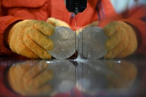 A researcher at Japan's Hokkaido University Institute of Low Temperature Science cuts a slice from an ice core sample taken from a glacier in the Pamir mountain range in Tajikistan